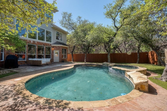 view of swimming pool featuring a patio area, a fenced backyard, outdoor lounge area, and a pool with connected hot tub