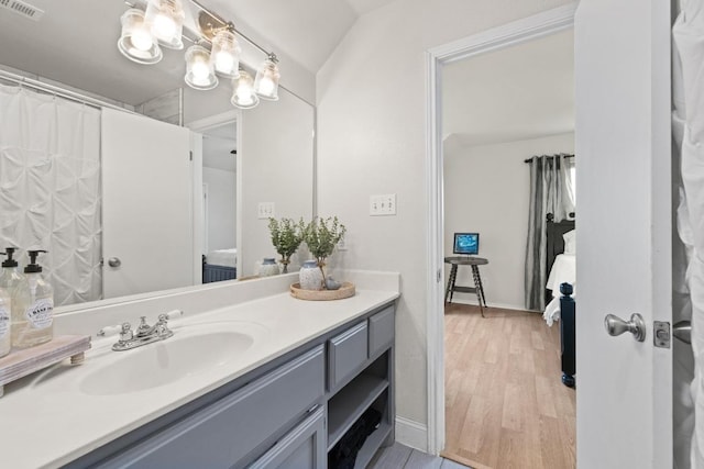 full bath with baseboards, wood finished floors, visible vents, and vanity