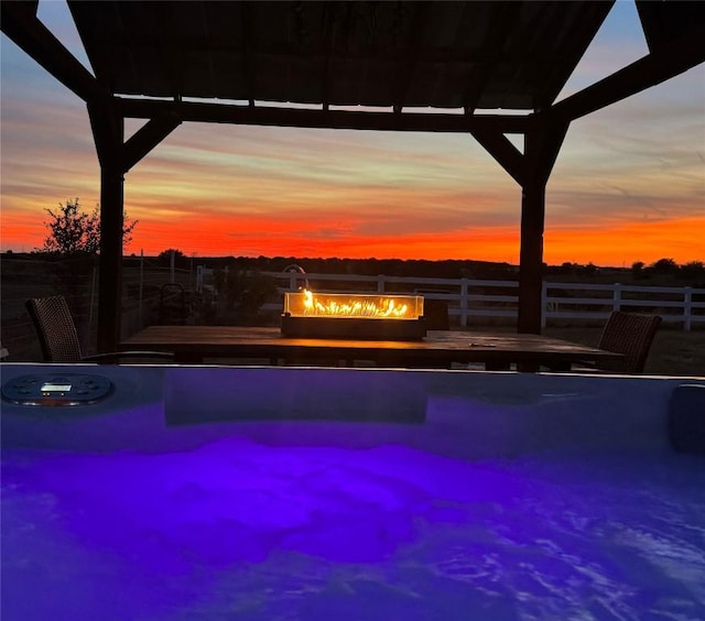 view of pool with a fire pit, a grill, fence, and an infinity pool
