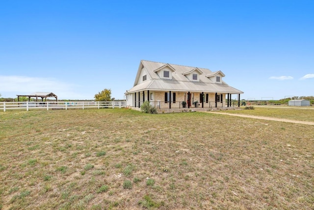 farmhouse inspired home featuring a front lawn, fence, and a porch
