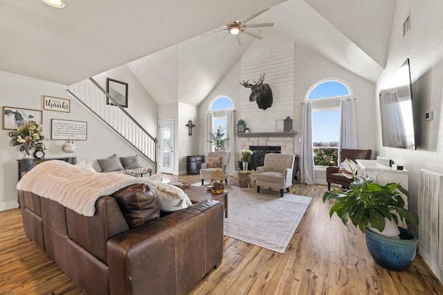 living area featuring high vaulted ceiling, wood-type flooring, visible vents, and ceiling fan
