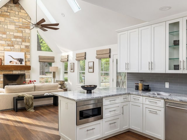 2608 S 2nd St, Austin, TX 78704 - kitchen featuring stainless steel dishwasher, a peninsula, white cabinetry, a ceiling fan, and beam ceiling