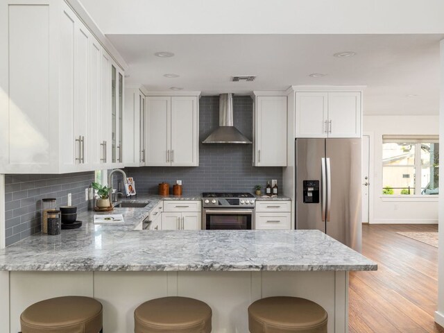 2608 S 2nd St, Austin, TX 78704 - kitchen featuring wall chimney exhaust hood, a sink, stainless steel appliances, light stone countertops, and recessed lighting