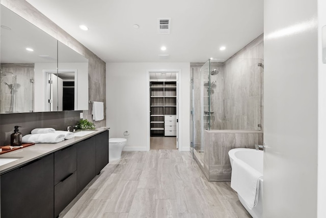 44 E Ave Unit 2301, Austin, TX 78701 - bathroom featuring a shower stall, a sink, a walk in closet, a freestanding bath, and visible vents