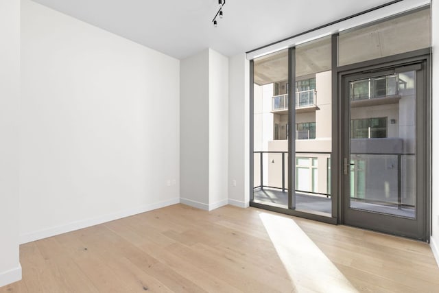 44 E Ave Unit 2301, Austin, TX 78701 - spare room with a wall of windows, wood finished floors, and baseboards