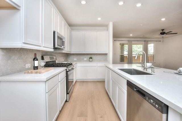 141 Green Knoll Ln, Georgetown, TX 78628 - kitchen featuring stainless steel appliances, a sink, light wood-type flooring, white cabinetry, and recessed lighting