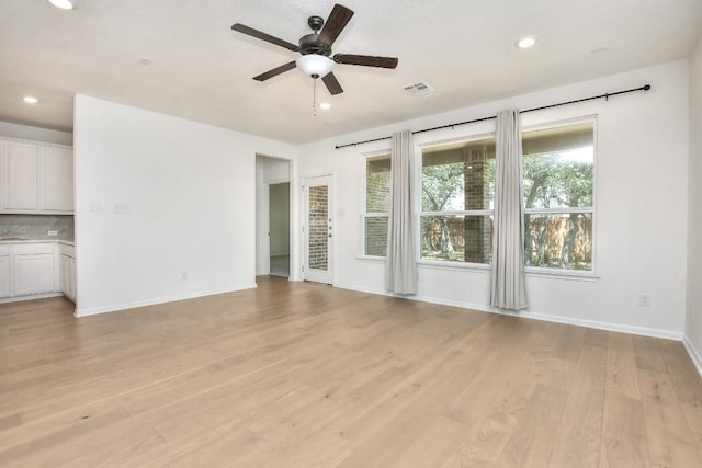 141 Green Knoll Ln, Georgetown, TX 78628 - unfurnished living room with a ceiling fan, baseboards, light wood-style flooring, and recessed lighting