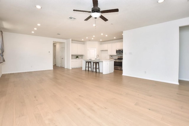 141 Green Knoll Ln, Georgetown, TX 78628 - unfurnished living room with recessed lighting, a sink, a ceiling fan, light wood-style floors, and baseboards