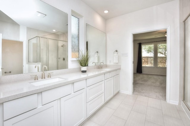 141 Green Knoll Ln, Georgetown, TX 78628 - bathroom featuring double vanity, a shower stall, baseboards, ceiling fan, and tile patterned floors