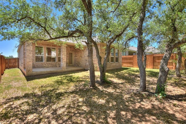 141 Green Knoll Ln, Georgetown, TX 78628 - view of front of house with brick siding, a fenced backyard, and a patio area