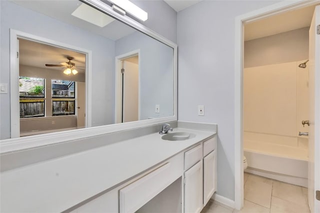 full bath featuring tile patterned flooring, toilet, vanity, tub / shower combination, and baseboards