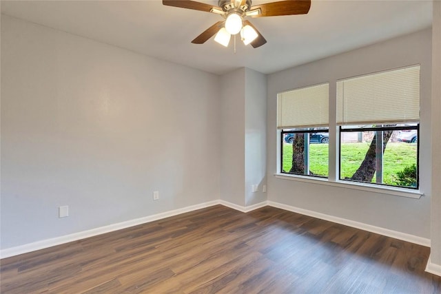 spare room with dark wood-type flooring, baseboards, and ceiling fan