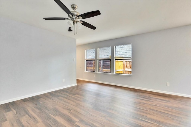 unfurnished room featuring wood finished floors, baseboards, and ceiling fan