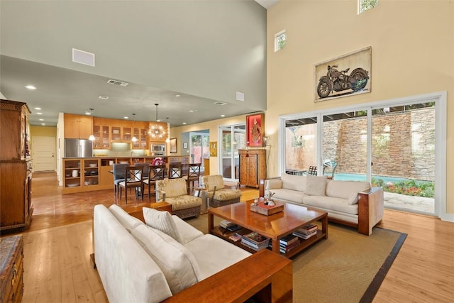 6209 Ledge Mountain Dr, Austin, TX 78731 - living room featuring light wood-style floors, a high ceiling, and recessed lighting