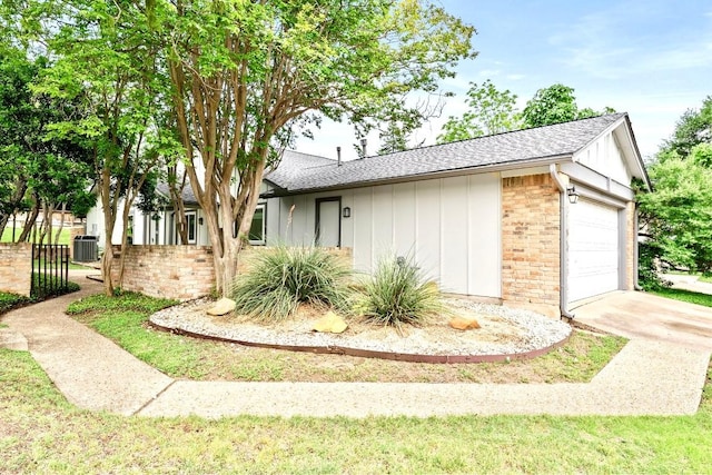 1702 Coturnix Dr, Austin, TX 78758 - view of side of home with board and batten siding, roof with shingles, a garage, cooling unit, and brick siding