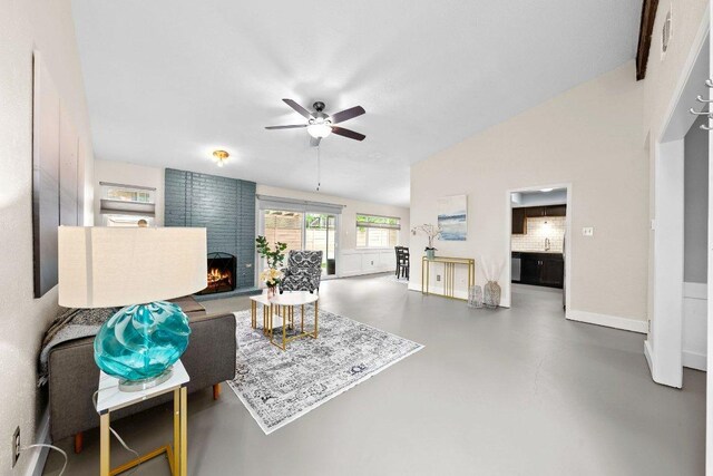 living area featuring vaulted ceiling, finished concrete flooring, a brick fireplace, baseboards, and a ceiling fan