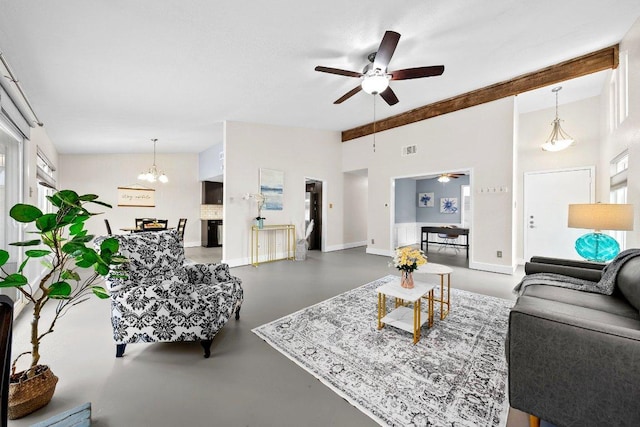 living area featuring concrete floors, ceiling fan with notable chandelier, baseboards, visible vents, and lofted ceiling