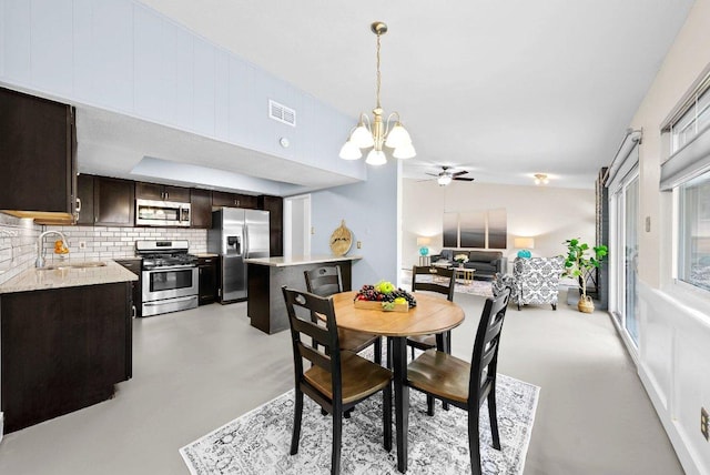dining room with concrete floors, visible vents, and ceiling fan with notable chandelier