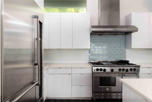 2105 Goodrich Ave Unit 7, Austin, TX 78704 - kitchen featuring high quality appliances, wall chimney exhaust hood, white cabinets, light countertops, and backsplash