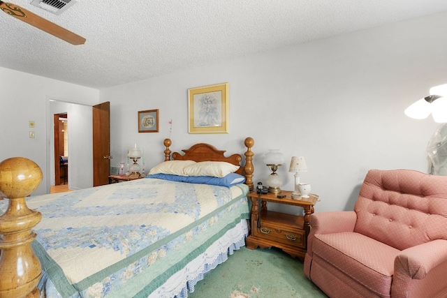 bedroom with a textured ceiling, carpet, visible vents, and a ceiling fan