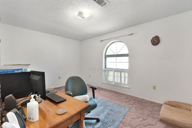 office featuring a textured ceiling, visible vents, carpet flooring, and baseboards