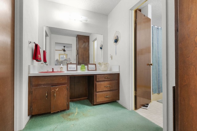 full bathroom with curtained shower, a textured ceiling, carpet flooring, and vanity