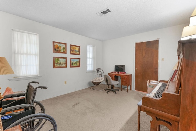 office area featuring a textured ceiling, carpet, and visible vents