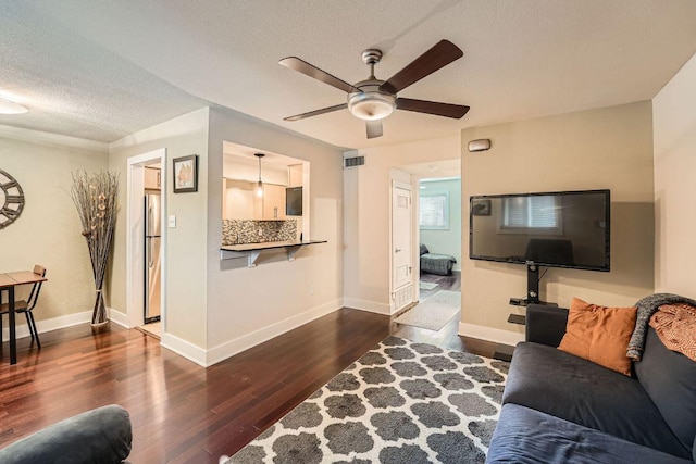 3815 Guadalupe St Unit 103, Austin, TX 78751 - living area featuring dark wood-style floors, ceiling fan, and a textured ceiling