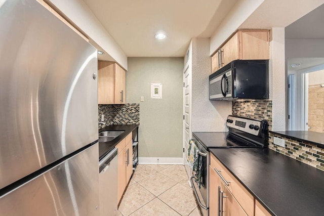 3815 Guadalupe St Unit 103, Austin, TX 78751 - kitchen with appliances with stainless steel finishes, light brown cabinetry, dark countertops, light tile patterned floors, and recessed lighting