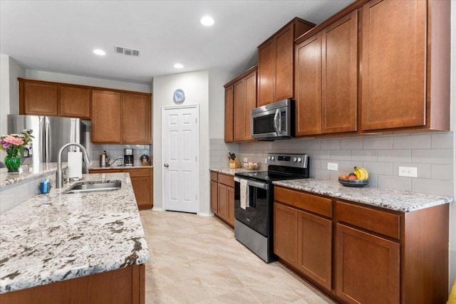 30305 Tiger Woods Dr, Georgetown, TX 78628 - kitchen featuring stainless steel appliances, a sink, brown cabinetry, and recessed lighting