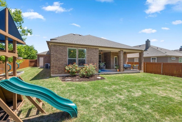 30305 Tiger Woods Dr, Georgetown, TX 78628 - rear view of house with a playground, brick siding, central air condition unit, a patio area, and roof with shingles
