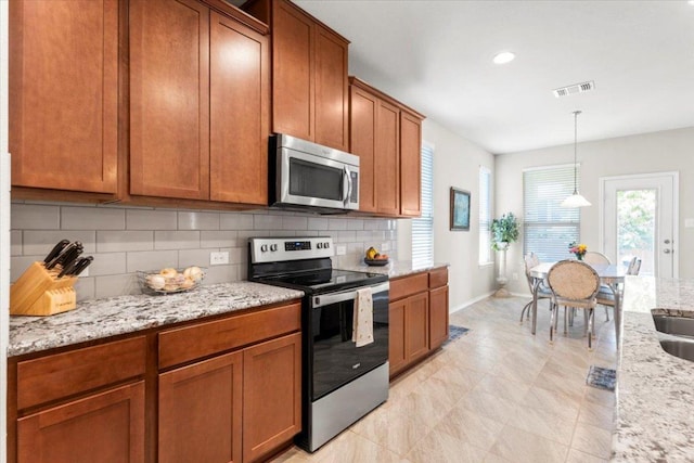 30305 Tiger Woods Dr, Georgetown, TX 78628 - kitchen featuring appliances with stainless steel finishes, decorative backsplash, brown cabinetry, baseboards, and recessed lighting