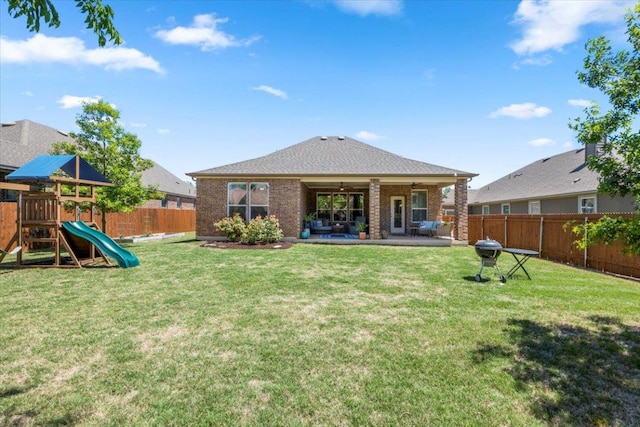 30305 Tiger Woods Dr, Georgetown, TX 78628 - back of property with brick siding, a ceiling fan, a patio area, and a playground