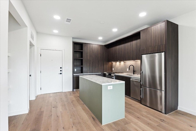 2209 S 1st St Unit 226, Austin, TX 78704 - kitchen with stainless steel appliances, open shelves, a center island, a sink, and light countertops
