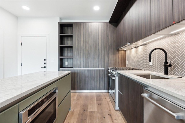 2209 S 1st St Unit 226, Austin, TX 78704 - kitchen with appliances with stainless steel finishes, a sink, light wood finished floors, light stone counters, and backsplash