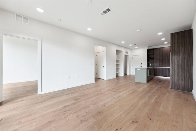 2209 S 1st St Unit 226, Austin, TX 78704 - unfurnished living room featuring recessed lighting, light wood-style flooring, baseboards, and built in shelves