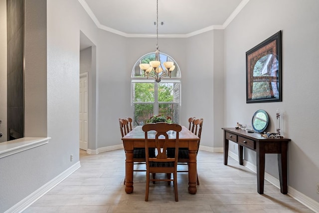 dining room featuring baseboards, ornamental molding, and an inviting chandelier