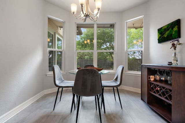 dining room with baseboards and a chandelier