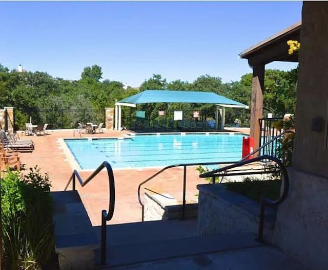 pool with fence and a patio