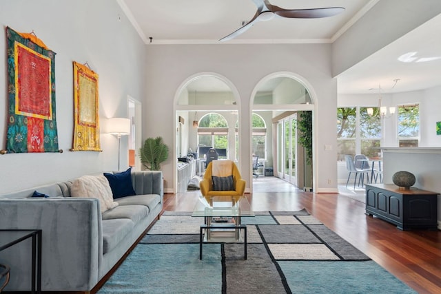 living room with ceiling fan, ornamental molding, and wood finished floors