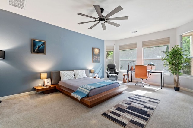 carpeted bedroom featuring baseboards, a ceiling fan, and visible vents