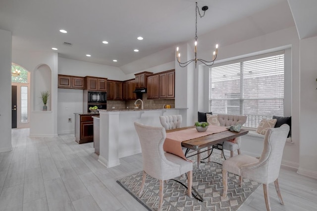 dining space with light wood finished floors, plenty of natural light, recessed lighting, and a chandelier