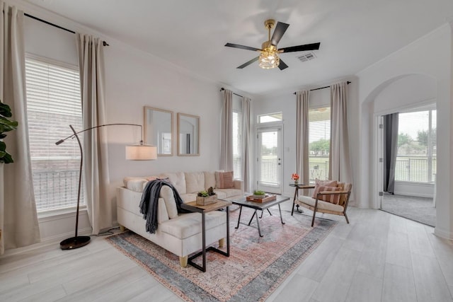 living room featuring ceiling fan, ornamental molding, wood finished floors, and visible vents