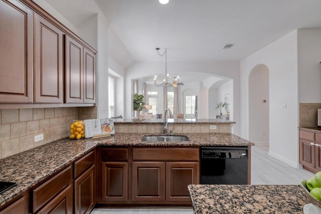 kitchen with a peninsula, a sink, dark stone counters, tasteful backsplash, and black dishwasher