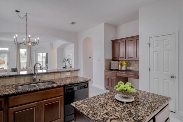 kitchen featuring arched walkways, a sink, dark stone countertops, tasteful backsplash, and black dishwasher