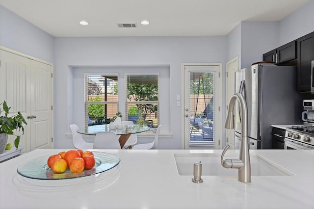 kitchen featuring recessed lighting, stainless steel appliances, light countertops, visible vents, and a sink