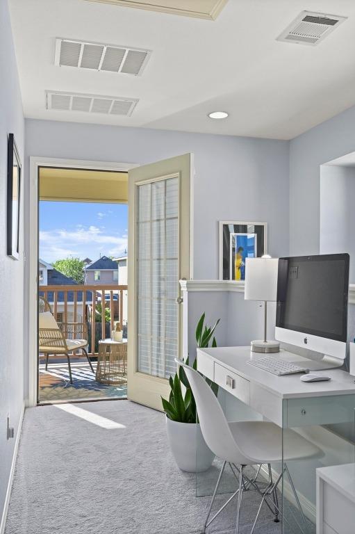 carpeted home office featuring visible vents