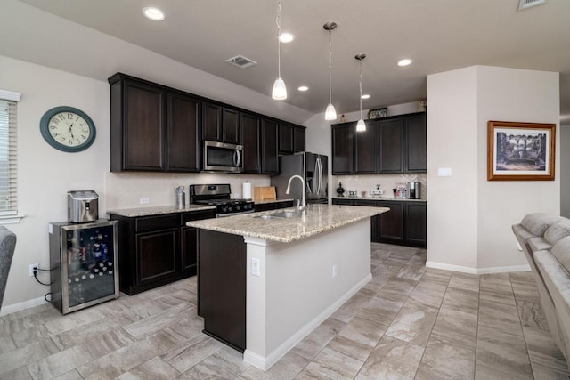 kitchen with a sink, visible vents, appliances with stainless steel finishes, light stone countertops, and wine cooler