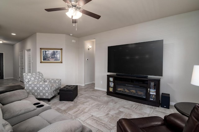 living room with baseboards, a ceiling fan, a glass covered fireplace, and recessed lighting