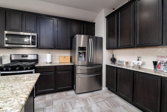 kitchen with light stone countertops, backsplash, and appliances with stainless steel finishes